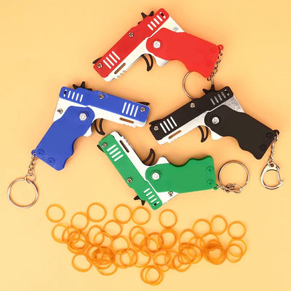 Llavero de pistola de goma de metal - Mini pistola de juguete de aleación con 60 gomas elásticas para juegos al aire libre, diversión en fiestas y regalos
